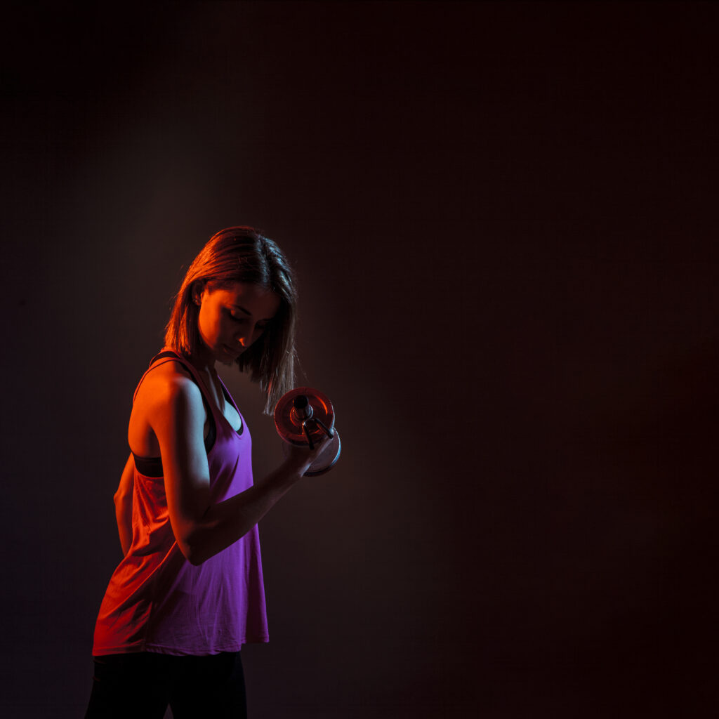 concentrated-woman-training-bicep-dark